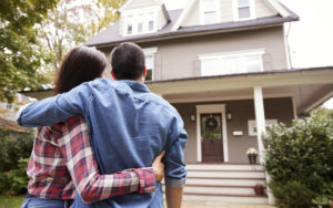 Couple standing in front of new home