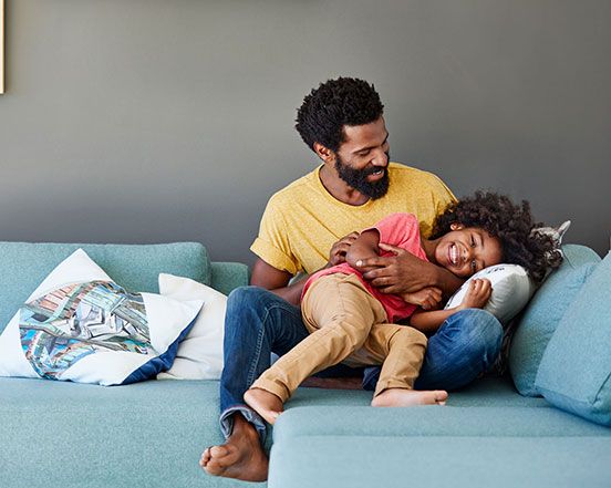 Dad playing with son on couch