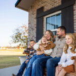 Family sitting on front porch swing